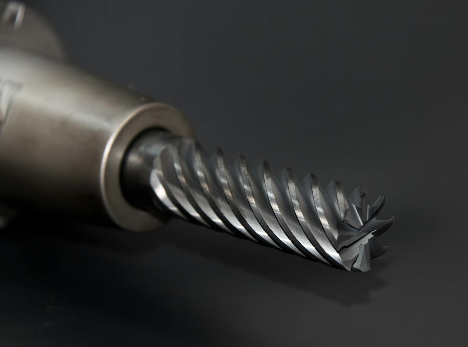 Mesin Bor Impact Cordless - High-quality close-up of a spiral drill bit showcasing metal textures on a black background.